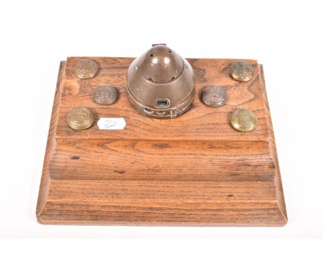 A WWI OR WWII TRENCH ART INKWELL AND WOODEN DESK TIDY, the inkwell has been converted from an inert bomb fuse and sits on a n