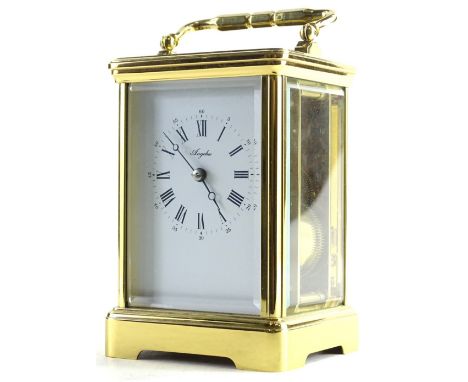 A brass carriage timepiece, the white enamel type dial stamped Angelus, with hinged handle, 18cm H.