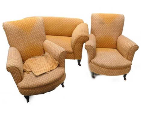 An Edwardian mahogany three piece suite, comprising two seater sofa with drop arm and two armchairs each upholstered in coral