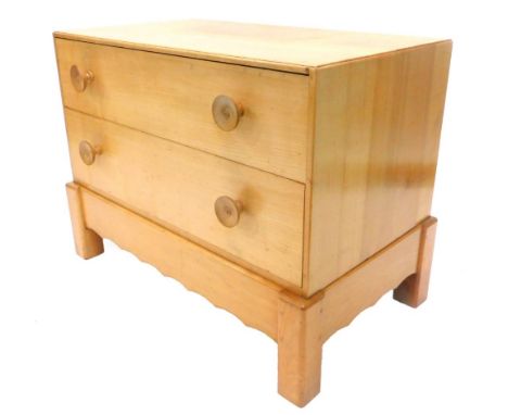 An Arts and Crafts fruitwood small chest of drawers, the caddy top above two drawers, each with turned wooden handles on bloc