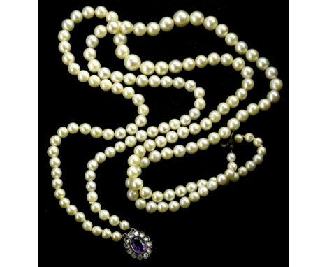 A cultured pearl two strand necklace, with a silver and marcasite clasp, with central purple stones, surrounded by white ston