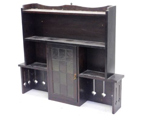 A late 19th/early 20thC Art Nouveau wall mounted shelf unit, with a raised back above two shelves, and a central leaded and g