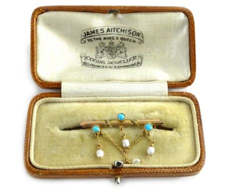 A Victorian 9ct gold bar brooch, set with three turquoise stones, and with seed pearl v shaped drop, set with three seed pear