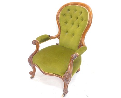 A Victorian walnut show frame open armchair, with a padded button back, padded arms and seat on cabriole legs, with ceramic c