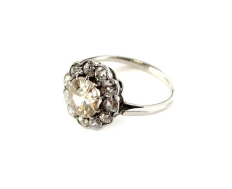 A diamond daisy cluster ring, with central round brilliant cut diamond, appears pinky/yellow in colour, approx 0.9cts, surrou