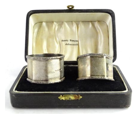 A pair of Edward VIII silver engine turned octagonal napkin rings, each in a fitted case, bearing retailers name of Henry Sim