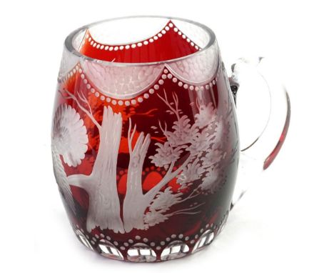 An early 20thC Bohemian clear frosted and ruby glass tankard, with c scroll handle, main body decorated with birds and flower