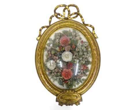 A mid 19thC French silk flower display, representing roses, leaves and other similar flowers, in oval gesso frame, the crest 