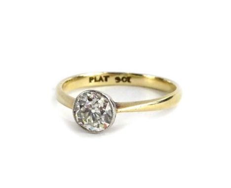 A 9ct gold and platinum diamond solitaire ring, set with round brilliant cut diamond, in platinum rub over setting, the diamo