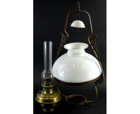 An early 20thC milk glass wrought iron and brass hanging lantern, with clear chimney, brass reservoir, removable milk glass s