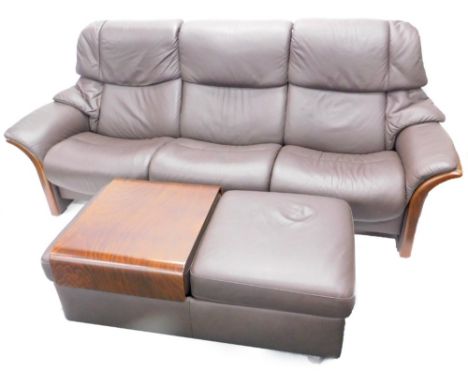 A Stressless dark brown leather three seater sofa, with show frame ends and supports, and a double foot stool.