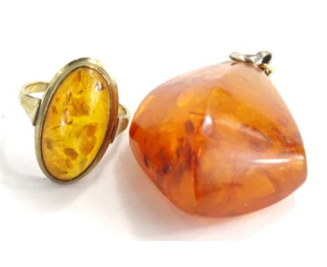 Two items of imitation amber jewellery, comprising a oval set dress ring, on a yellow metal band, stamped 333, ring size J, t