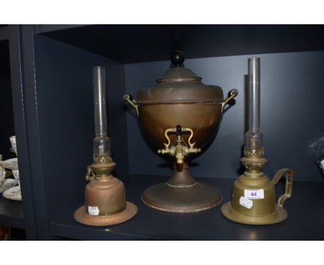 Two antique brass cased chamber stick style oil lamps with a copper samovar