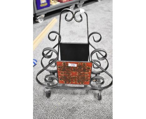A mid century magazine rack having wrought iron frame work with red glazed ceramic tiles