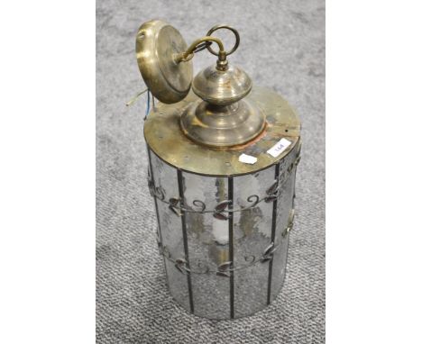 A large ceiling lantern light having rolled glass windows with leaded light wrap around foliage