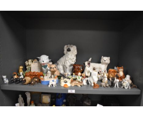 A large collection of ceramic cat and dog figure studies including half a bookend, pipe holder and Wade
