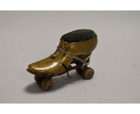 An early 20th century novelty pin cushion in the form of a Roller Skate with brass case and rotating wheels