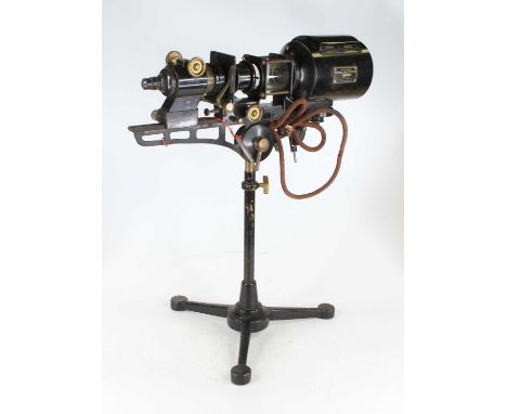 An early 20th century black lacquered and brass microscope slide projector on telescopic cast iron tripod base, bearing a lab