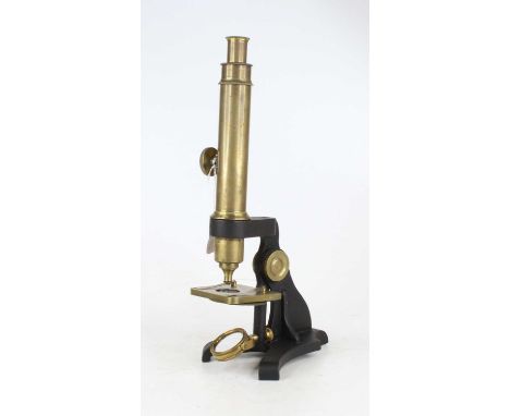 An early 20th century lacquered brass monocular microscope, having an adjustable mirror on a cast iron base, height 39cm