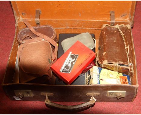 A leather case and contents to include pocket binoculars, ensign camera, moon lamp night lamp etc 