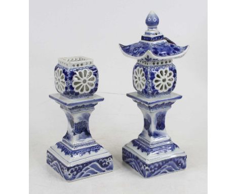 A pair of oriental style blue &amp; white porcelain tea light holders in the form of pagodas, height 30cm (one missing lid)