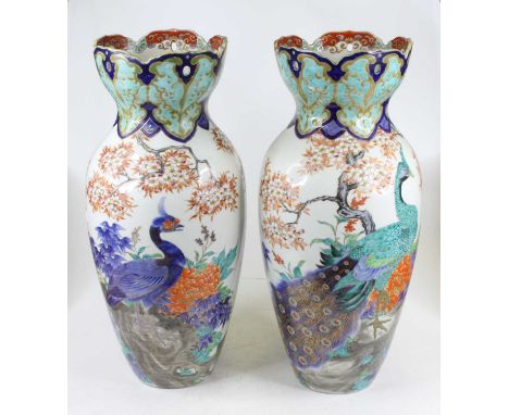 A pair of Japanese pottery vases of baluster form each having a flared reticulated neck, enamel decorated with peacocks among