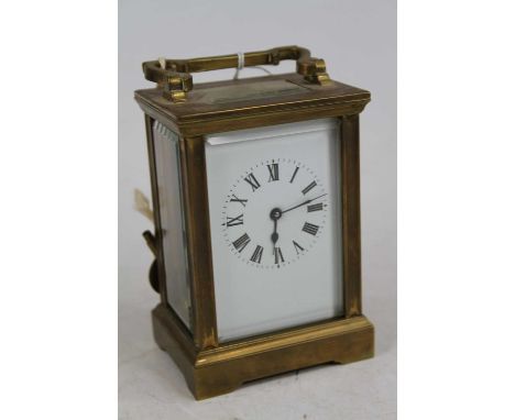 An early 20th century lacquered brass carriage clock, the enamel dial showing Roman numerals, having visible platform escapem