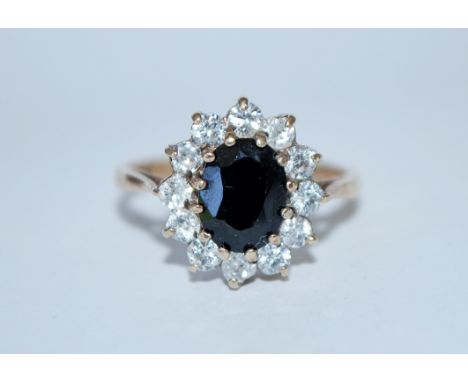 A hallmarked 9ct gold sapphire and white stone cluster ring. Hallmarked Birmingham. Size M. Weight 2.7g.