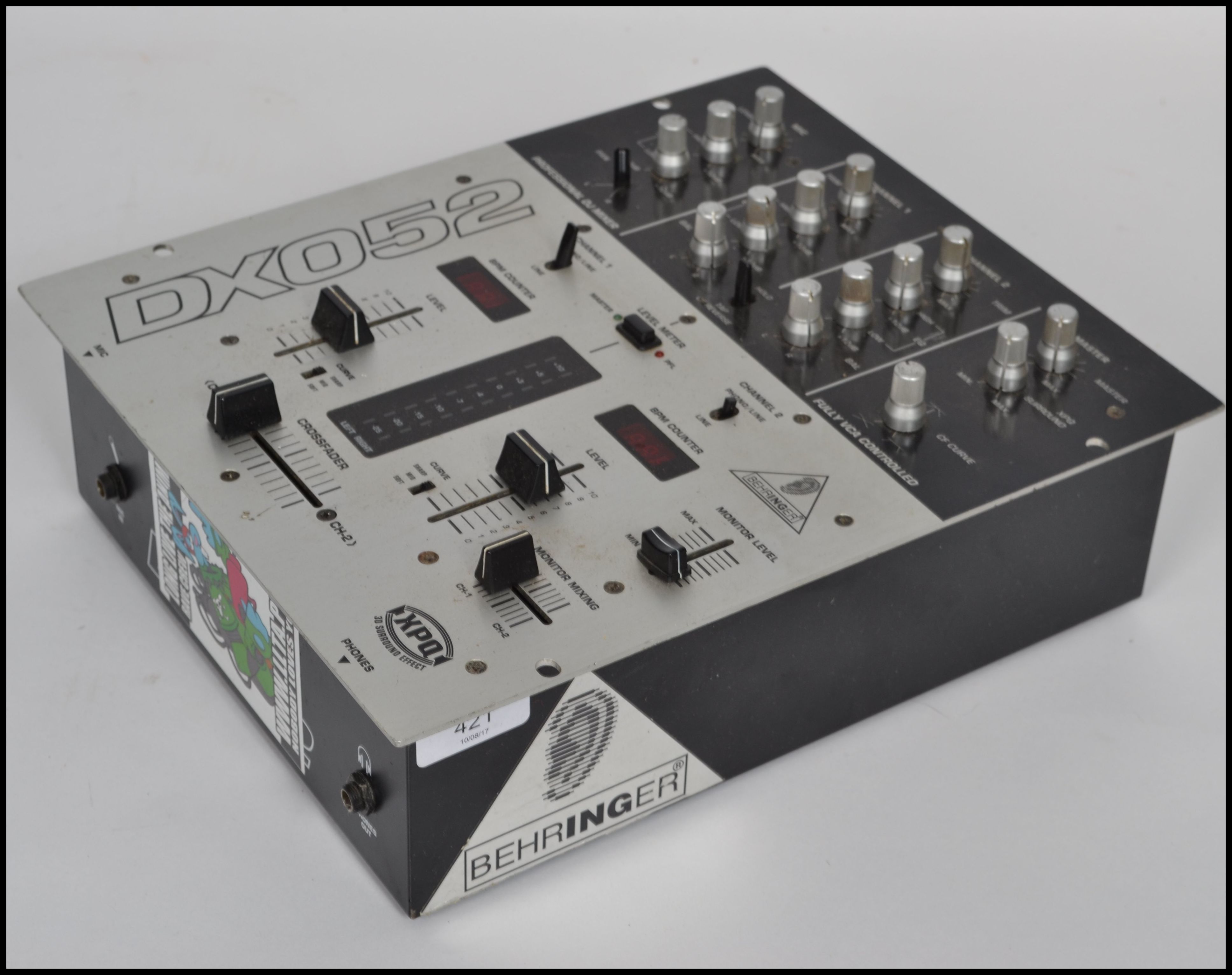 A vintage DX052 DJ mixer board in black and silver with dials to front.