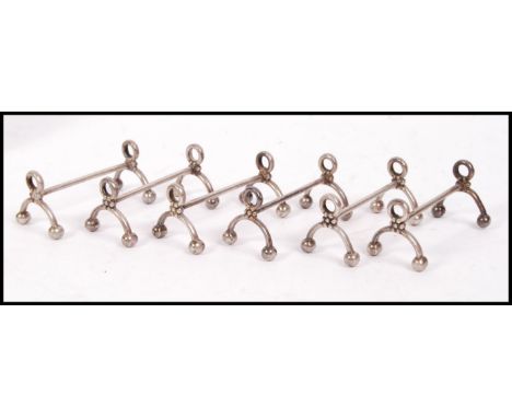 A set of 6 early 20th century Bruno Wiskemann silver plated knife rests of large form with pierced finial tops to each. Stamp