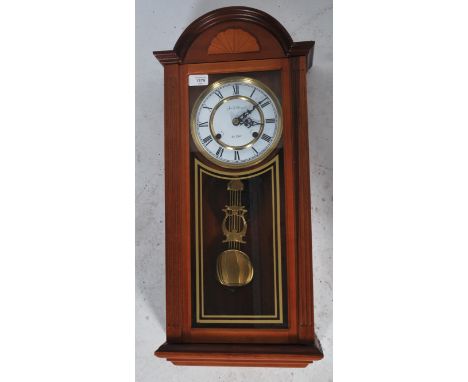 A James C Huntington wall clock having a 31 day movement with enamel face, faceted hands and roman numeral chapter ring.