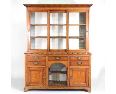 A late Victorian light oak dog kennel dresser, with a glazed plate rack, containing an arrangement of drawers and cupboards a