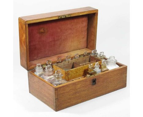 A 19th century oak cased apothecary box, the fitted interior containing labelled glass medicine bottles and scales, 32cm wide