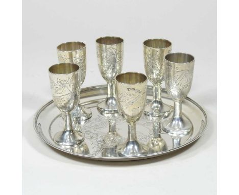 A Russian silver liqueur set, engraved with flowers, with six stem shot cups, 7cm high, on a circular tray, 16cm diameter, 16