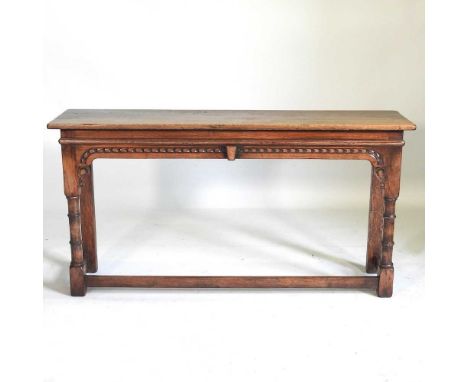 A carved oak console table, 20th century, on turned legs, united by a stretcher137w x 36d x 71h cm 