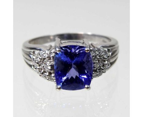 An 18 carat white gold, diamond and tanzanite dress ring, the central stone approximately three carats, flanked by diamond se