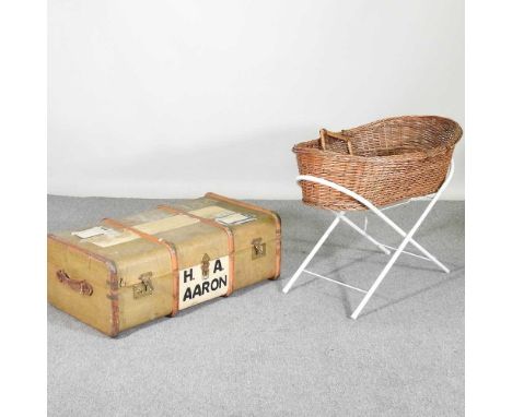 An early 20th century wooden bound trunk, 89cm wide, together with a moses basket on stand (2)