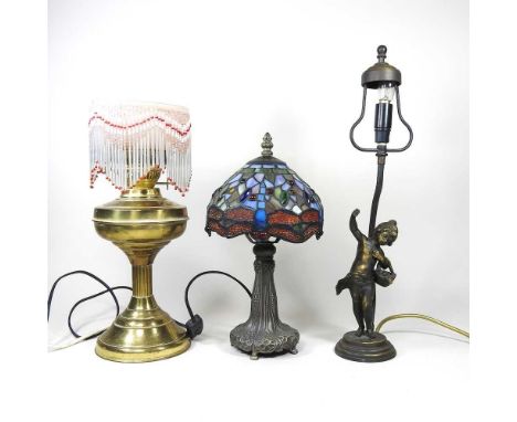 A converted brass oil lamp, together with a Tiffany style table lamp and a figural table lamp (3)All are dirty, one has no sh