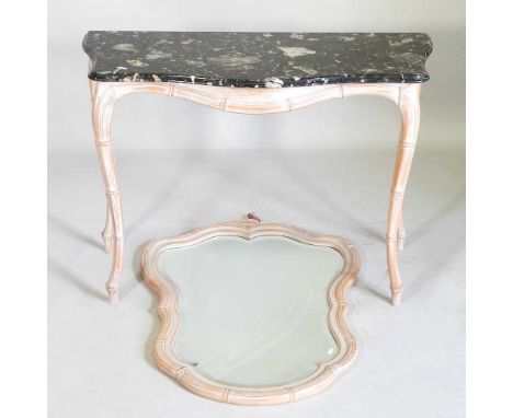 A carved wooden and limed console table, with a shaped marble top, 103cm wide, together with a matching wall mirror (2)110w x