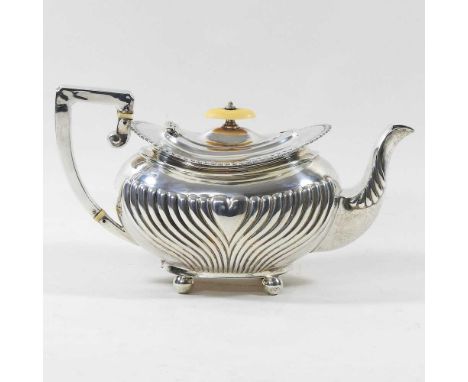 An Edwardian silver teapot, with a half gadrooned body and angular handle, on ball feet, Sheffield 1903, 658g, 28cm long. Not