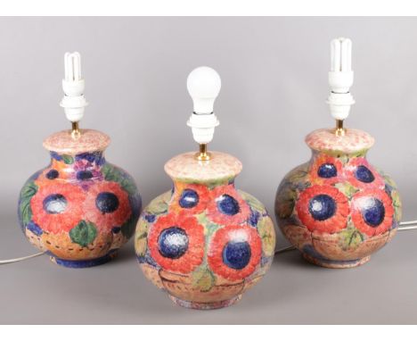 A trio of ceramic table lamps depicting poppies.  Some slight chips to one example.