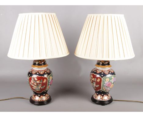 A pair of Chinese ceramic table lamps, produced by C.A. Lighting.  Small scuffs to bases.