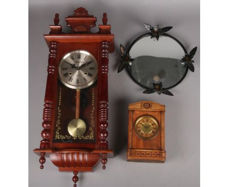 A mahogany 31 day wall clock along with a small mantel clock and a framed convex mirror.  