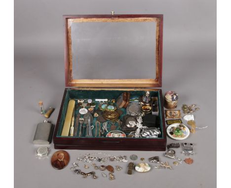 A wooden and glazed bijouterie cabinet with an assortment of collectables. To include a Stratton mini compact, enamel pins an