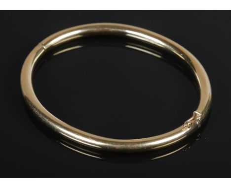 A 9ct Gold filled hinged bangle. Stamped 375 to the inside of the clasp. Diameter 7cm. Total weight: 21.95g  