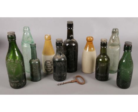 A box of vintage glass and stoneware bottles and a corkscrew. Mainly Sheffield examples.  
