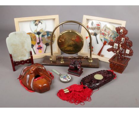 A collection of mostly wood oriental items. Includes framed hand fans, table gong, jade coloured tablet, mask etc.  