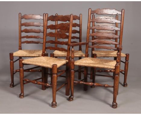 A set of five oak framed ladder back rush seat dining chairs, including one carver.  