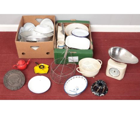 Two boxes of mostly vintage kitchenalia. Including jelly mould, red enamel teapot, scales, colander, enamel chamberstick, cas