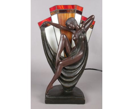 A Tiffany style table lamp, depicting a woman draped in a sheet, in front of stained glass fan panel. Base stamped Crosa 1993